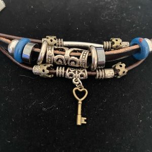 3 strand leather and bead bracelet with charms and buckle clasp.